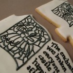 Piping black royal icing between the color blocks of the stained glass designs