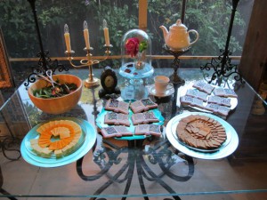 Patio table display for Beauty & the Beast, including my brass candlestick, a small clock, teacup and teapot as you-know-who