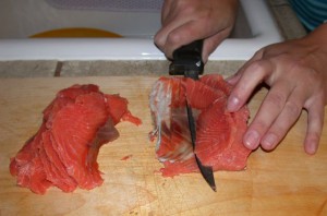 Slicing the salt fish thin across the grain