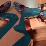 Sewing bronze ribbon trim on the shoes