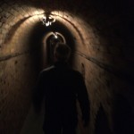 Ghoulish Glen leading the way through the dark arched hallways