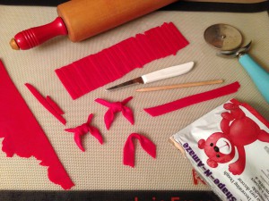 Sculpting the tassels and scarves from red edible clay