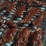 Freshly-drizzled melted chocolate over baked bacon slices
