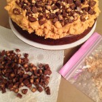 Adding goodies over the peanut butter fudge frosting layer