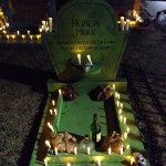 Gravestone with candles alight, some decorations, still needs FLOWERS...