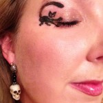 Cat makeup with eye closed with elegant skull earrings