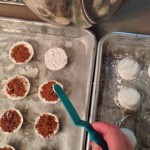 Icing the bottoms of the mini cupcake heads with full-strength royal icing