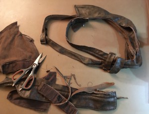 Cutting leather jacket scraps into Rey's double-belt