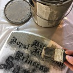 Carefully brushing the gray basecoat without painting the recessed epitaphs