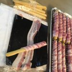 Wrapping breadstick wands in bacon